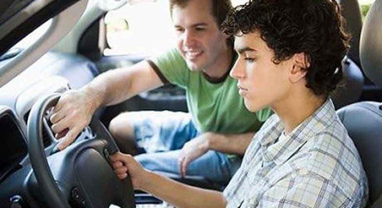 A student driver at the wheel with the instructor alongside